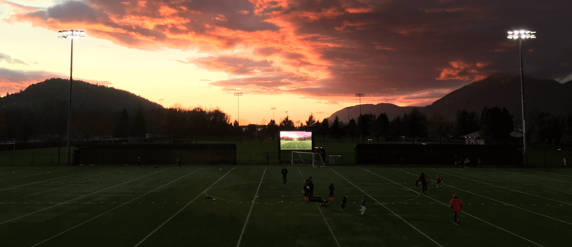 Футбольное поле на фоне гор и заката солнца
